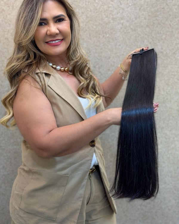 Dalva Mineiro segurando uma mecha longa de mega-hair